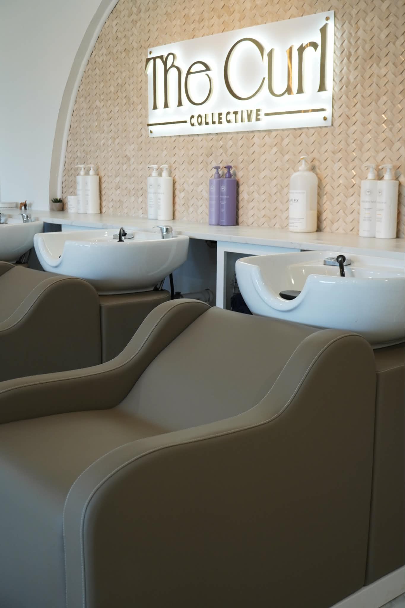 Wash stations with The Curl Collective sign